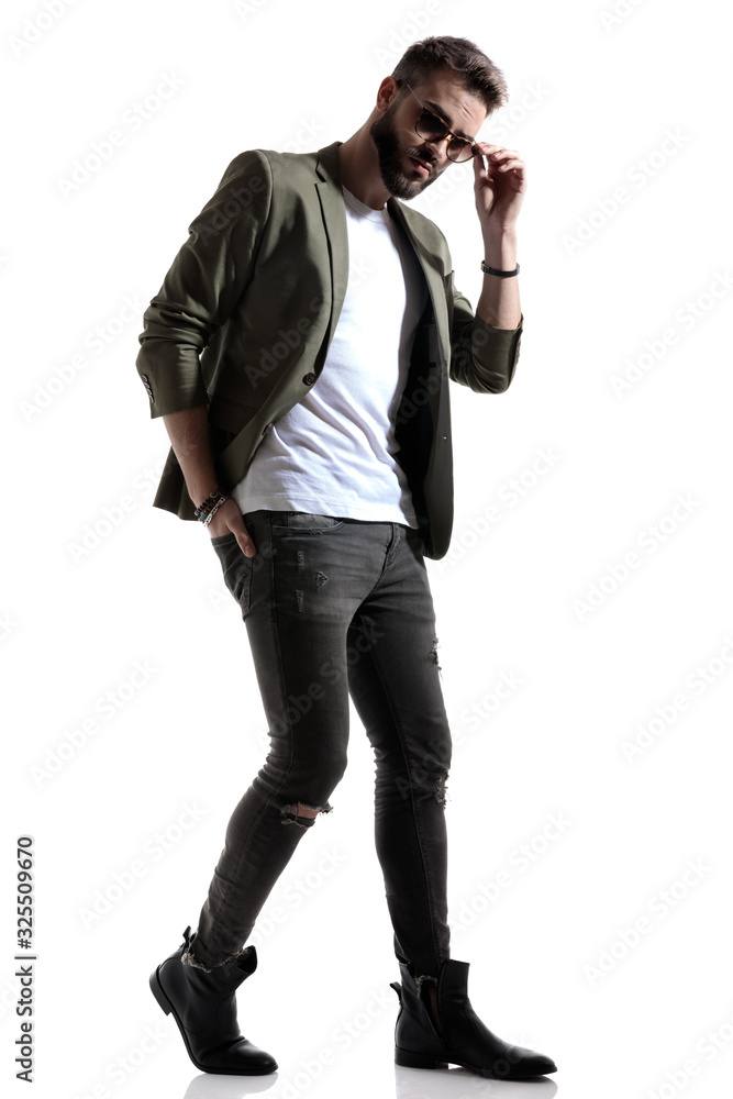 Charming fashion model fixing his sunglasses Charming fashion model fixing his sunglasses