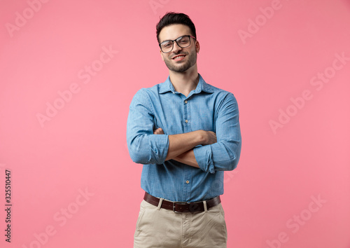 happy young man smiling and crossing arms