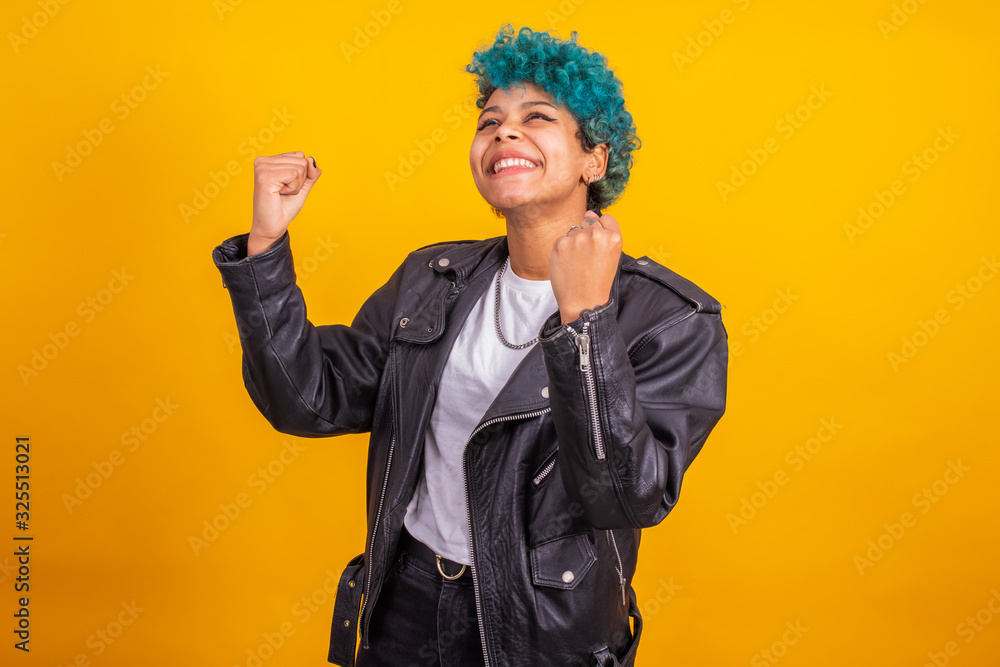 young modern brunette girl with curly blue hair of afro american ethnicity isolated on color background young modern brunette girl with curly blue hair of afro american ethnicity isolated on color background