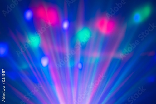 blurred laser light in a disco or night club with visible light rays and color circles in a misty environment.