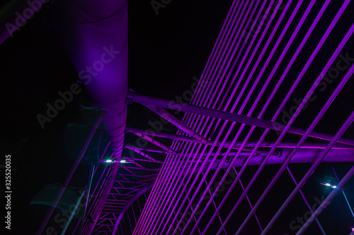 The illuminated structure of the Seri Saujana Bridge at night. One of many bridges in Putrajaya, Malaysia, all alternately illuminated in unison in different colors. Putrajaya Bridge Malaysia at night photo