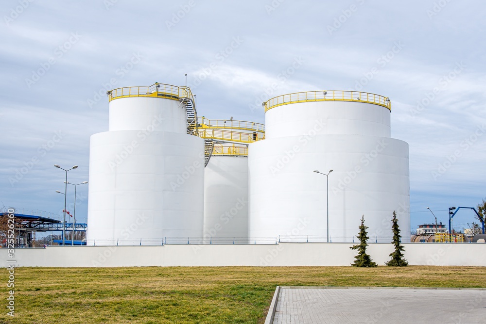 Group of large steel storage tanks at refinery Group of large steel storage tanks at refinery