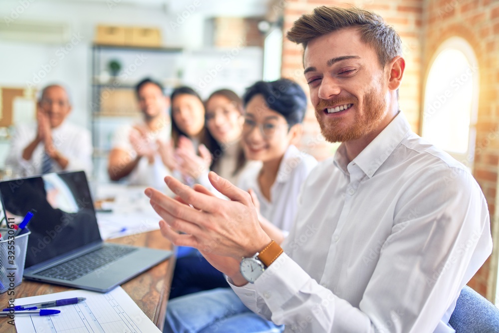 Group of business workers smiling happy and confident. Working together with smile on face looking at the camera applauding at the office Group of business workers smiling happy and confident. Working together with smile on face looking at the camera applauding at the office