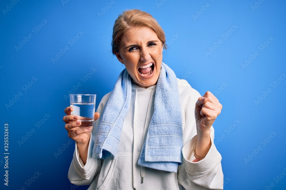 Middle age beautiful blonde sportswoman wearing towel drinking glass of water to refreshment screaming proud and celebrating victory and success very excited, cheering emotion Middle age beautiful blonde sportswoman wearing towel drinking glass of water to refreshment screaming proud and celebrating victory and success very excited, cheering emotion