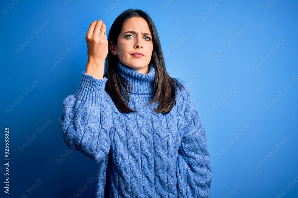 Young brunette woman with blue eyes wearing casual turtleneck sweater Doing Italian gesture with hand and fingers confident expression Young brunette woman with blue eyes wearing casual turtleneck sweater Doing Italian gesture with hand and fingers confident expression
