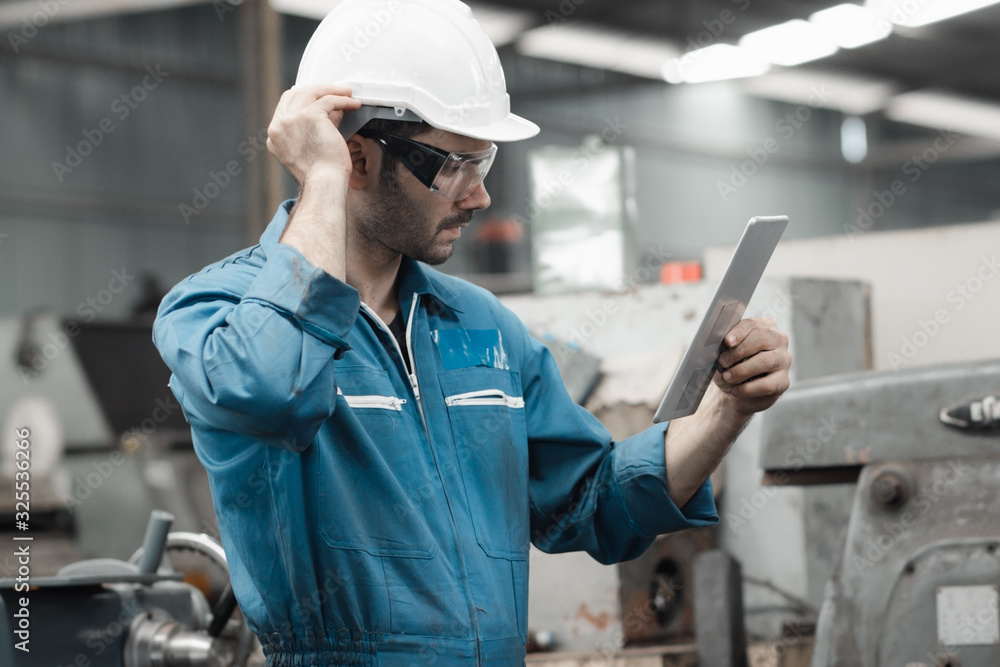 Maintenance engineer industrial plant with a tablet in hand and document plan, Engineer looking of working at industrial machinery setup in factory. Maintenance engineer industrial plant with a tablet in hand and document plan, Engineer looking of working at industrial machinery setup in factory.