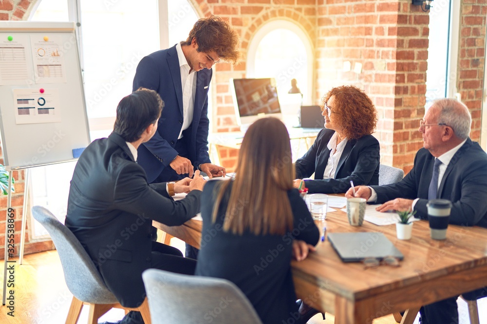 Group of business workers working together in a meeting. Listening one of them speaking at the office. Group of business workers working together in a meeting. Listening one of them speaking at the office.