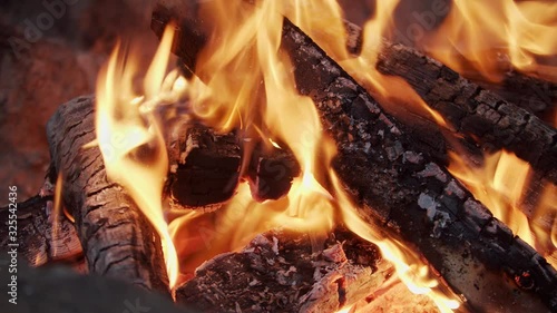A camp fire is burning wood outside