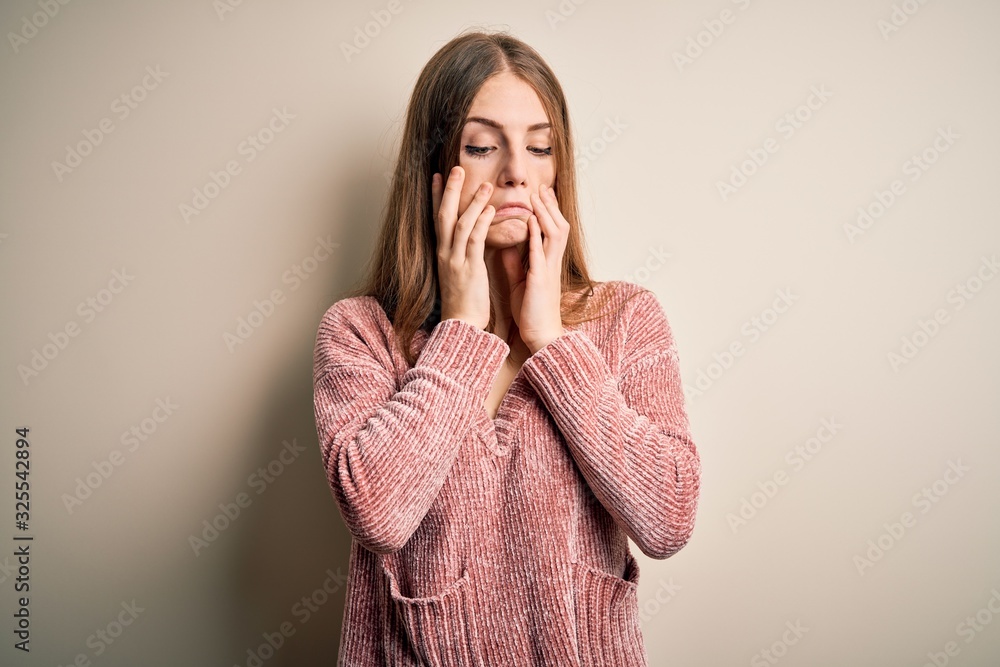 Young beautiful redhead woman wearing pink casual sweater over isolated white background Tired hands covering face, depression and sadness, upset and irritated for problem Young beautiful redhead woman wearing pink casual sweater over isolated white background Tired hands covering face, depression and sadness, upset and irritated for problem