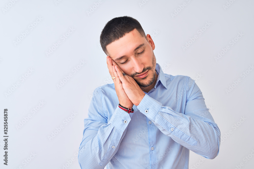 Young handsome business man standing over isolated background sleeping tired dreaming and posing with hands together while smiling with closed eyes. Young handsome business man standing over isolated background sleeping tired dreaming and posing with hands together while smiling with closed eyes.