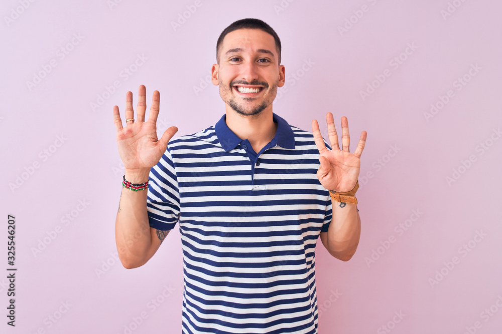 Young handsome man wearing nautical striped t-shirt over pink isolated background showing and pointing up with fingers number nine while smiling confident and happy. Young handsome man wearing nautical striped t-shirt over pink isolated background showing and pointing up with fingers number nine while smiling confident and happy.