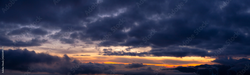 Beautiful and striking aerial view of the puffy clouds during a colorful sunset. Taken near Vancouver, British Columbia, Canada. Panorama
