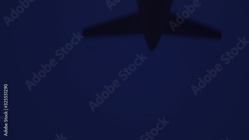Dramatic shot of an airplane landing in foggy conditions by night.