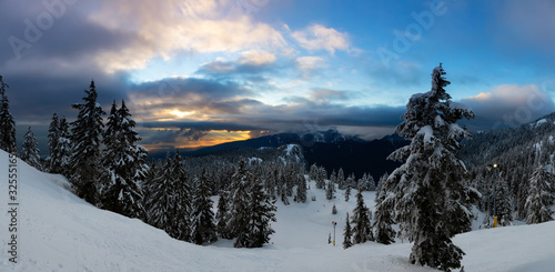 Beautiful Panoramic Nature Landscape View from the Mountain Top and Downtown City in the Background during a vibrant winter sunset. Taken in Seymour, Vancouver, British Columbia, Canada.