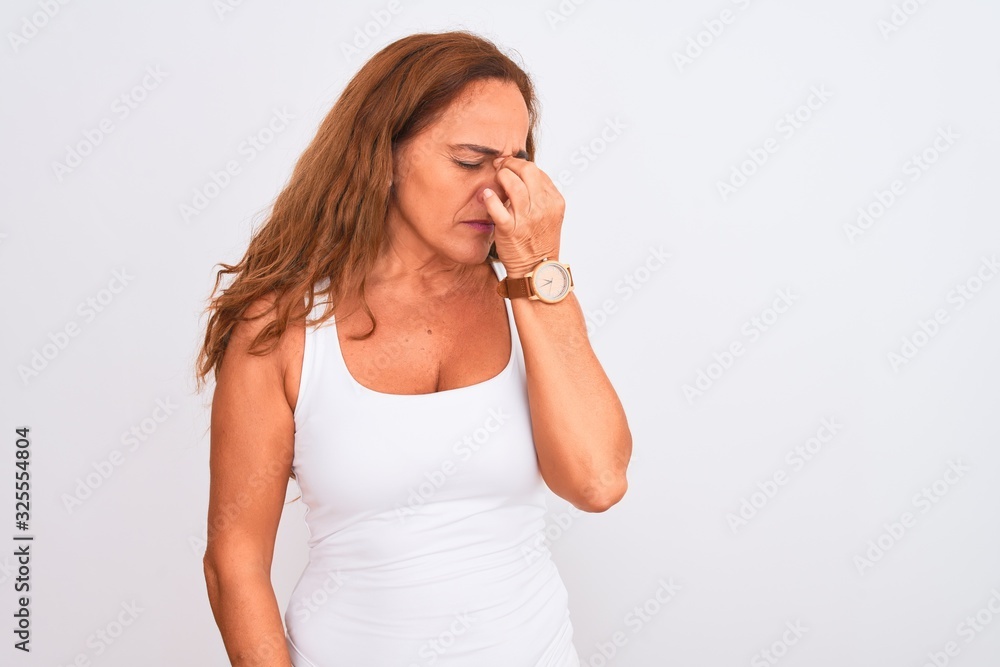 Middle age mature woman standing over white isolated background tired rubbing nose and eyes feeling fatigue and headache. Stress and frustration concept. Middle age mature woman standing over white isolated background tired rubbing nose and eyes feeling fatigue and headache. Stress and frustration concept.