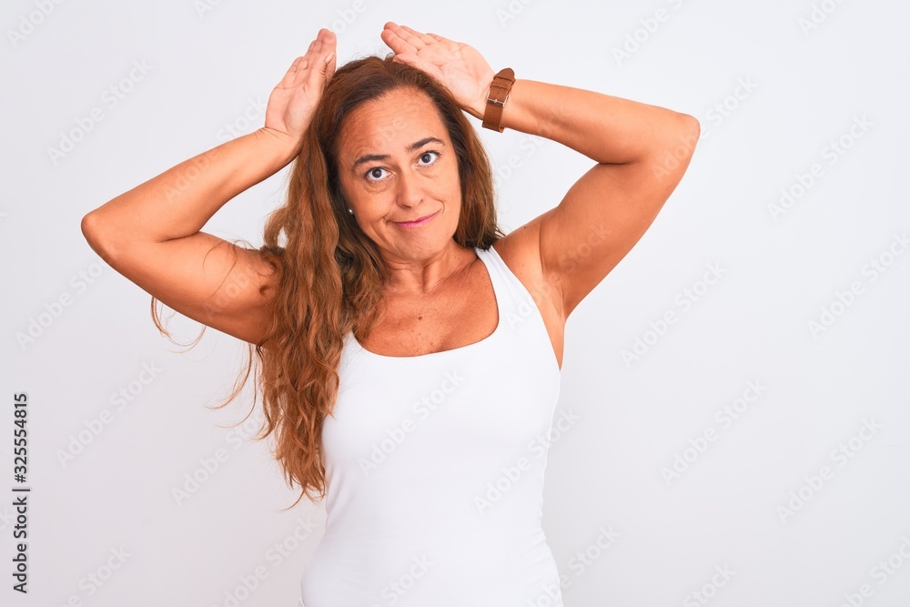 Middle age mature woman standing over white isolated background Doing bunny ears gesture with hands palms looking cynical and skeptical. Easter rabbit concept. Middle age mature woman standing over white isolated background Doing bunny ears gesture with hands palms looking cynical and skeptical. Easter rabbit concept.
