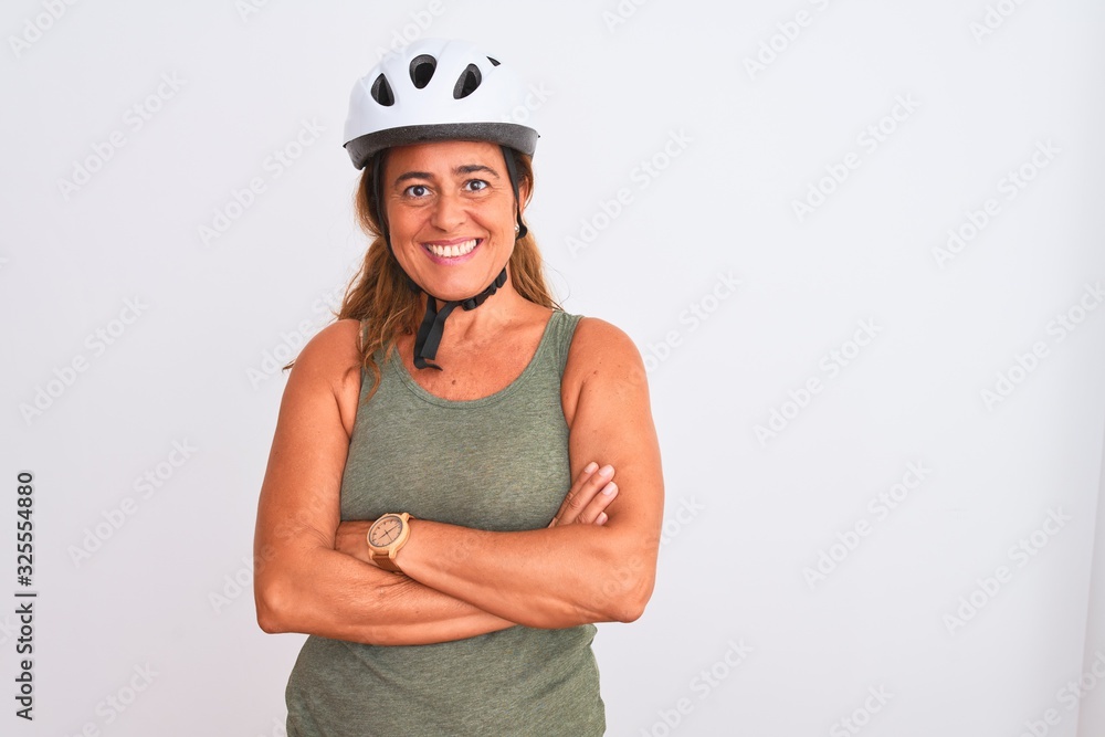 Middle age mature cyclist woman wearing safety helmet over isolated background happy face smiling with crossed arms looking at the camera. Positive person. Middle age mature cyclist woman wearing safety helmet over isolated background happy face smiling with crossed arms looking at the camera. Positive person.
