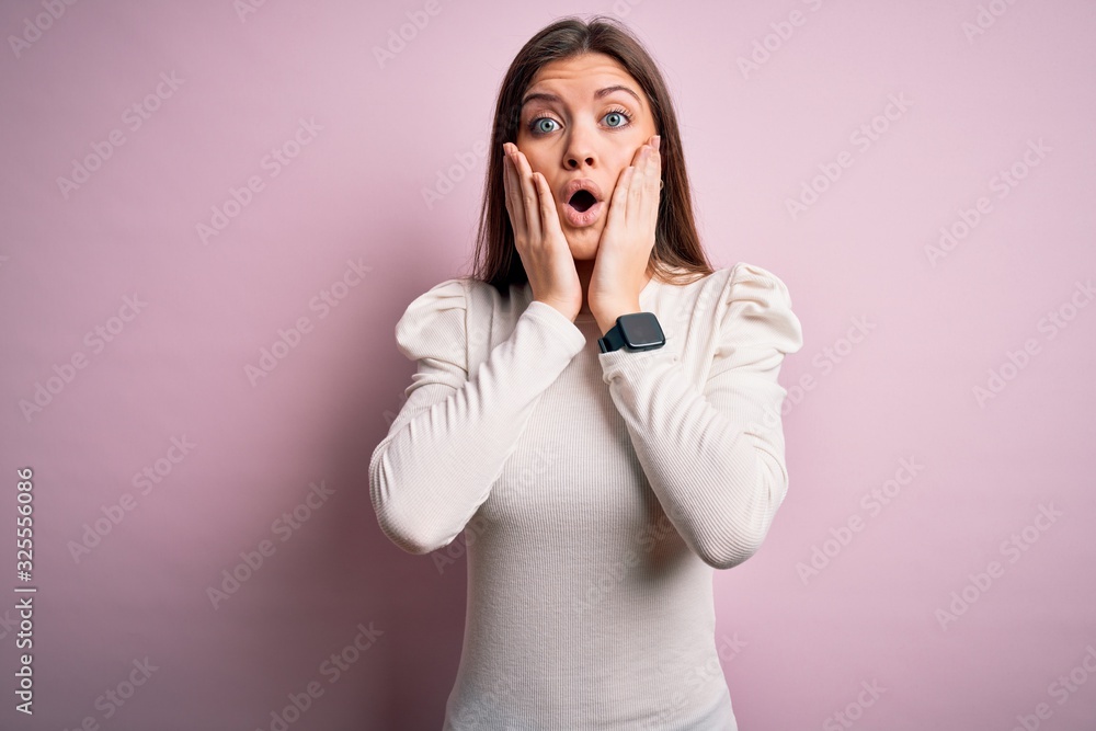 Young beautiful woman with blue eyes wearing casual white t-shirt over pink background afraid and shocked, surprise and amazed expression with hands on face Young beautiful woman with blue eyes wearing casual white t-shirt over pink background afraid and shocked, surprise and amazed expression with hands on face