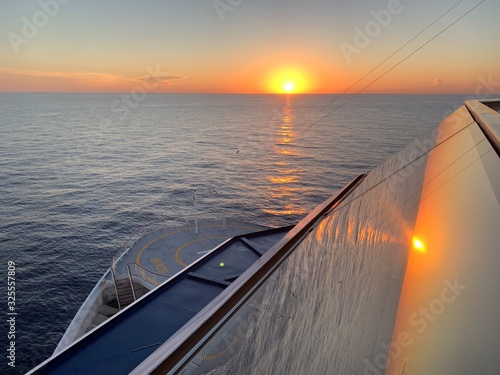 Cruise ship in the middle of the sea. Beautiful sunset with view from the bridge on a helipad.