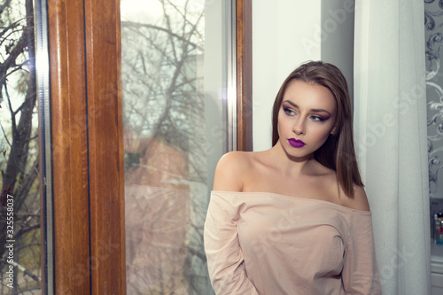 Dreaming young woman looking away in window