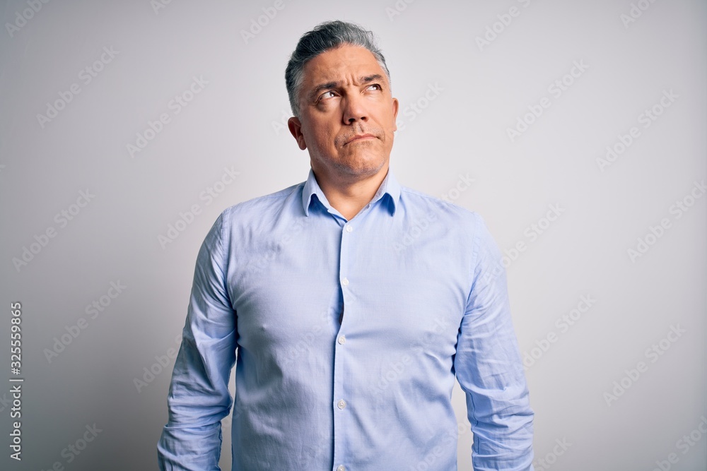 Middle age handsome grey-haired business man wearing elegant shirt over white background smiling looking to the side and staring away thinking. Middle age handsome grey-haired business man wearing elegant shirt over white background smiling looking to the side and staring away thinking.