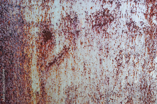 茶色い錆が浮いた白塗装した古い鉄板の表面