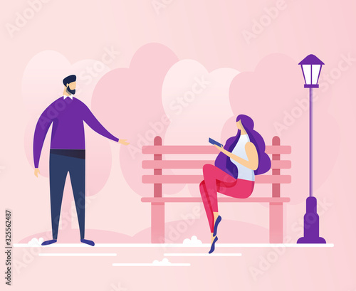 Young Bearded Brunet, Addressing Woman with Long Flowing Hair, Sitting on Bench Near Street Lamp in City Park with Electronic Book or Pad, Trying to Start Conversation or Romantic Acquaintance