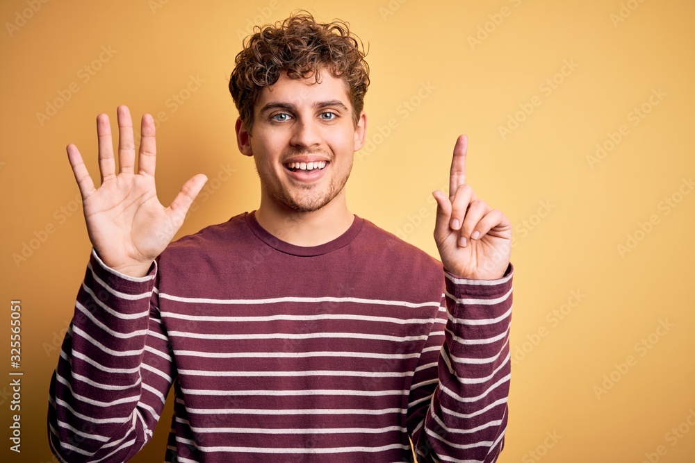 Young blond handsome man with curly hair wearing casual striped sweater showing and pointing up with fingers number six while smiling confident and happy. Young blond handsome man with curly hair wearing casual striped sweater showing and pointing up with fingers number six while smiling confident and happy.