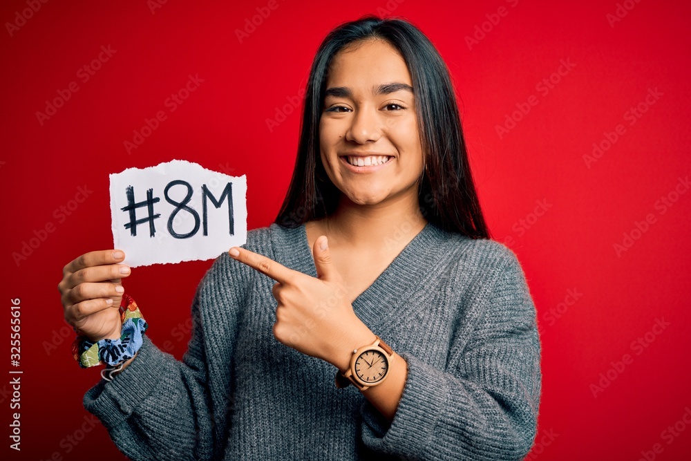 Young beautiful asian woman celebrating 8th march womens day holding reminder paper very happy pointing with hand and finger Young beautiful asian woman celebrating 8th march womens day holding reminder paper very happy pointing with hand and finger