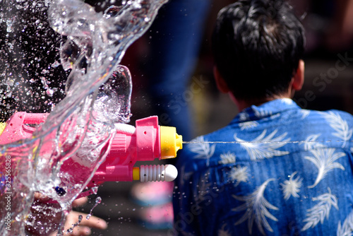 Freezing action of water wall and water gun while spitting out a stream of water in Songkran day, Thailand © Chartchai