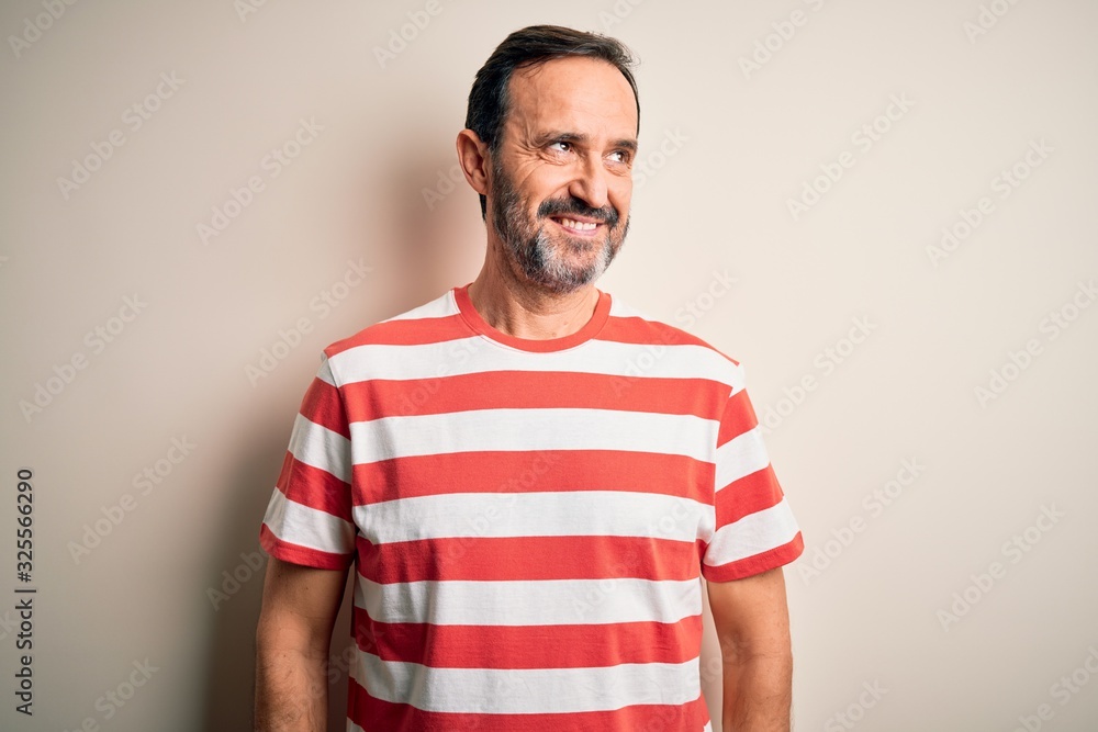 Middle age hoary man wearing casual striped t-shirt standing over isolated white background smiling looking to the side and staring away thinking. Middle age hoary man wearing casual striped t-shirt standing over isolated white background smiling looking to the side and staring away thinking.