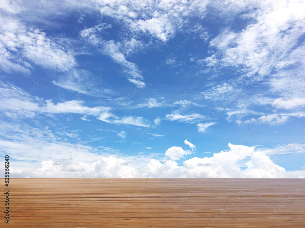 Wood table top over blue sky background with white clouds. Wood table top over blue sky background with white clouds.