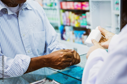Blur image  senior sick man stood to buy medicines from the female pharmacist in the pharmacy to cure the illness : Blurred background photo