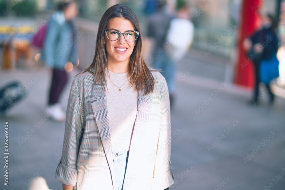 Fototapeta premium Young beautiful woman smiling happy and confident. Standing with smile on face at the town street