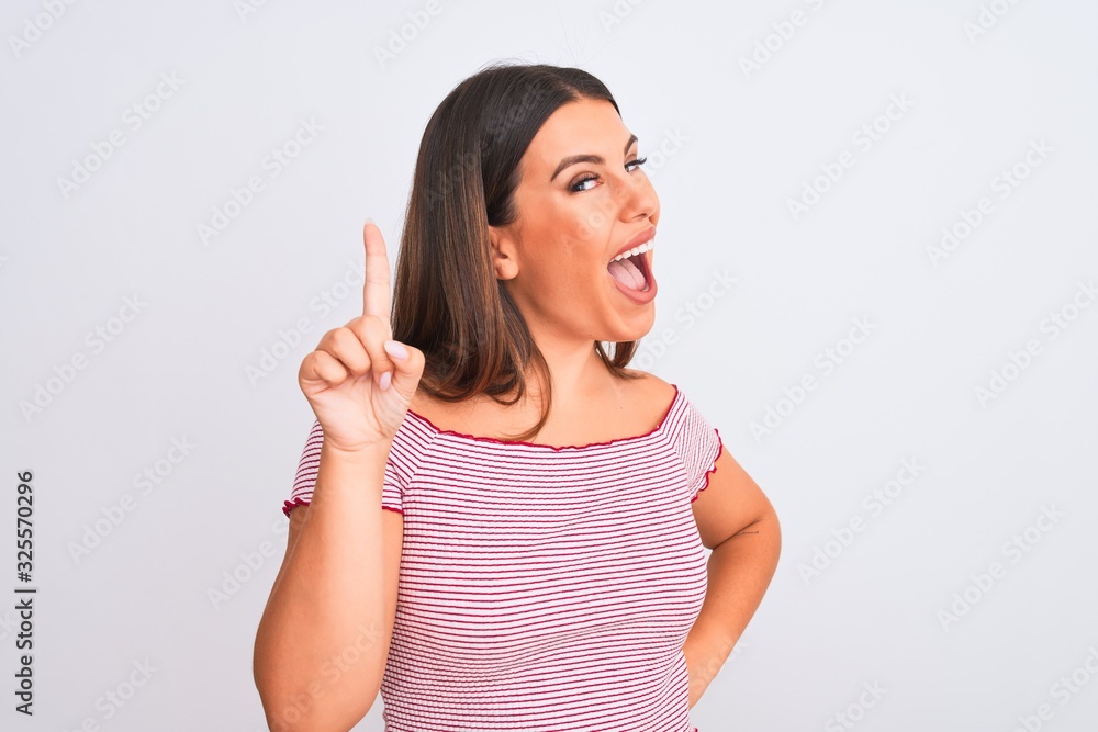 Portrait of beautiful young woman standing over isolated white background pointing finger up with successful idea. Exited and happy. Number one. Portrait of beautiful young woman standing over isolated white background pointing finger up with successful idea. Exited and happy. Number one.
