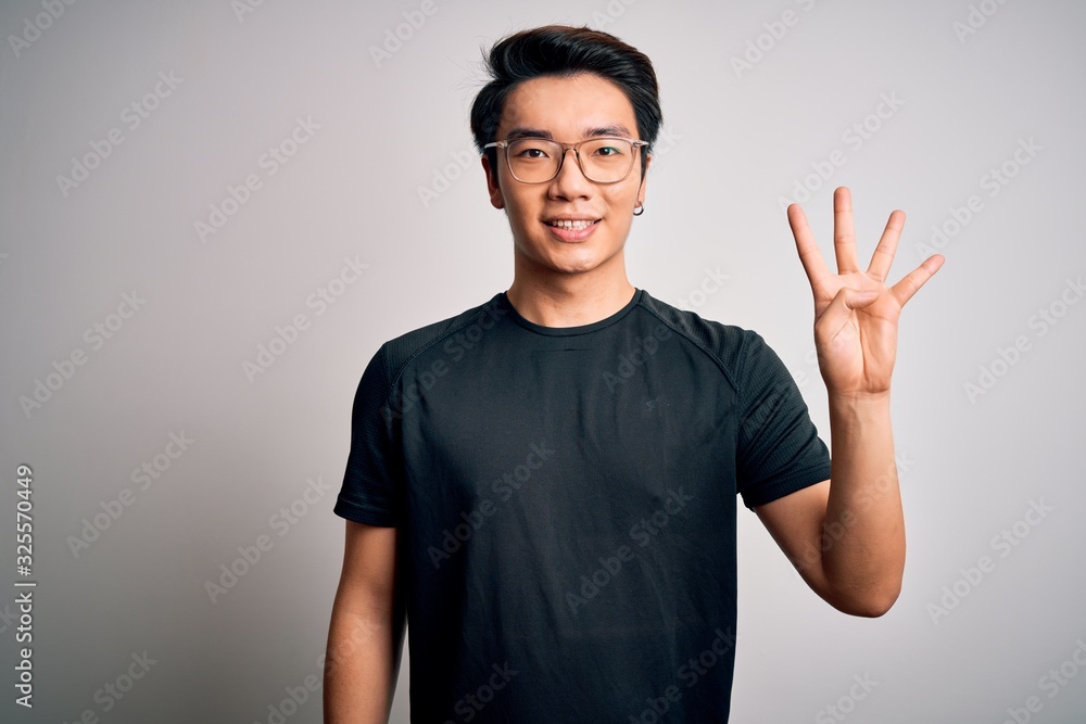 Young handsome chinese man wearing black t-shirt and glasses over white background showing and pointing up with fingers number four while smiling confident and happy. Young handsome chinese man wearing black t-shirt and glasses over white background showing and pointing up with fingers number four while smiling confident and happy.