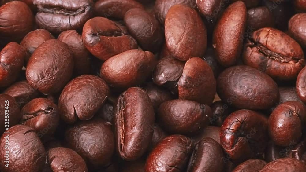 A lot of roasted coffe beans, close shot. Dolly shot of heap of brown coffee beans, abstract background. Selective soft focus. Blurred background A lot of roasted coffe beans, close shot. Dolly shot of heap of brown coffee beans, abstract background. Selective soft focus. Blurred background