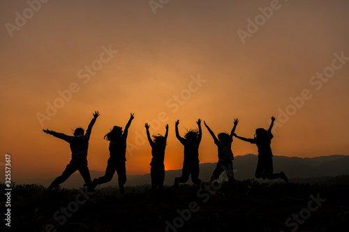 Group of happy people playing at summer sunset