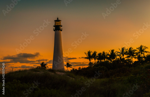 lighthouse lighted sunset sky coast sea ocean landscape architecture tower palms sun nautical nature florida