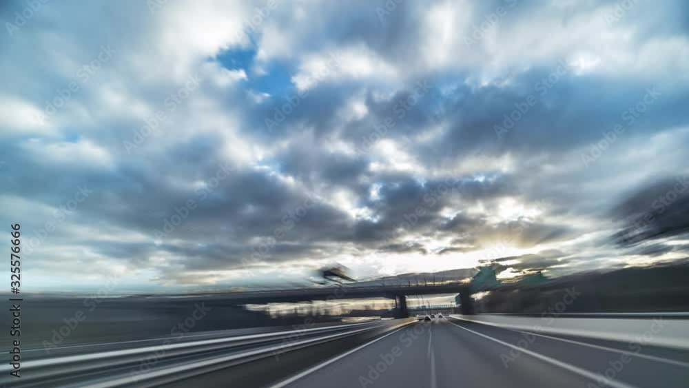 Driving on the Prague ring. Speeded up video. Traffic lights and signs, and the scenery is just a blur. Cars racing past. Clouds fly above the road. Driving on the Prague ring. Speeded up video. Traffic lights and signs, and the scenery is just a blur. Cars racing past. Clouds fly above the road.