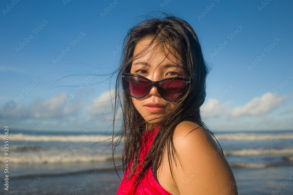 young beautiful and happy Asian Korean woman in sunglasses wearing sarong at the beach walking by the sea relaxed and cool enjoying Summer holiday young beautiful and happy Asian Korean woman in sunglasses wearing sarong at the beach walking by the sea relaxed and cool enjoying Summer holiday