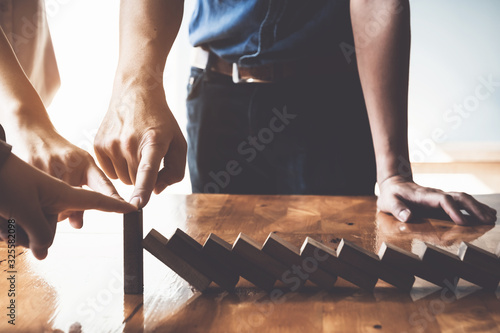 Business risk management concept. Business team stop wooden brick blog together.
