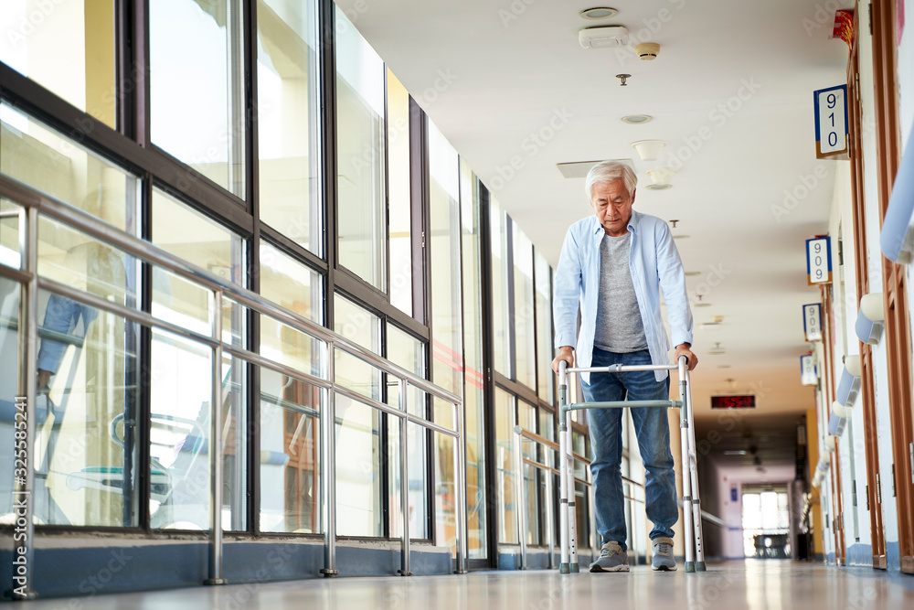 asian old man walking with a walker in nursing home