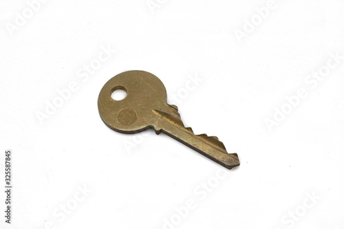 A brass deadbolt key, close up, isolated on a clean, white background.  Shot in macro. © Peter