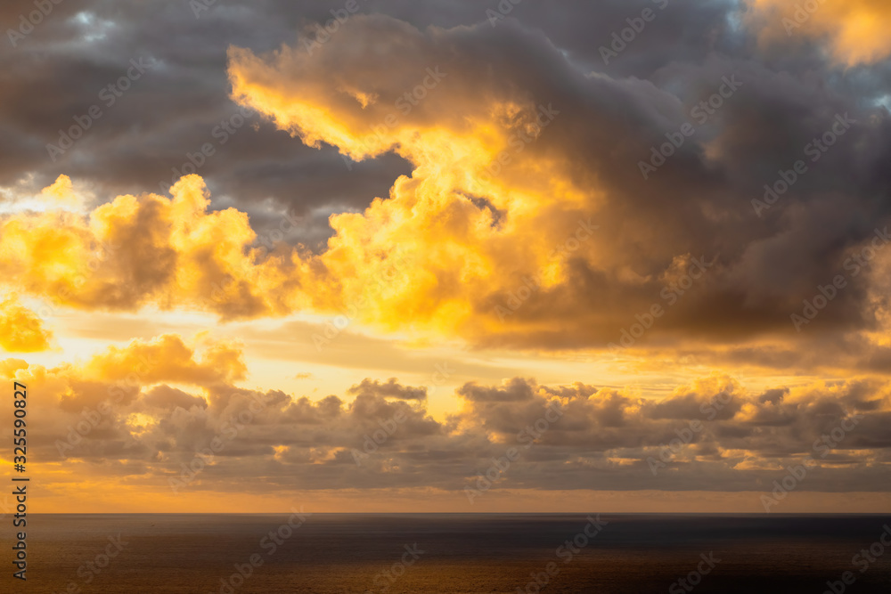 Aerial view of beautiful clouds lit by evening sunlight over dark ocean waters Aerial view of beautiful clouds lit by evening sunlight over dark ocean waters