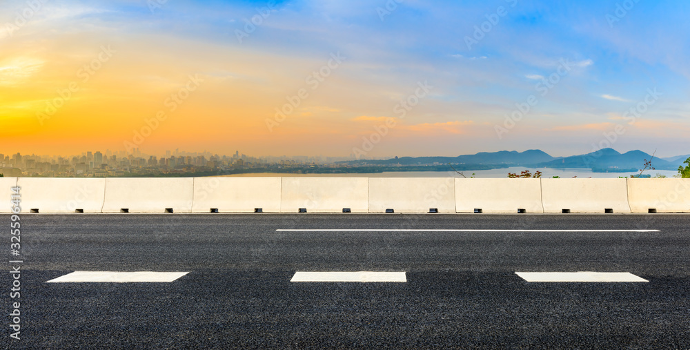 Fototapeta premium Empty asphalt road and city skyline at sunrise in Hangzhou,China.