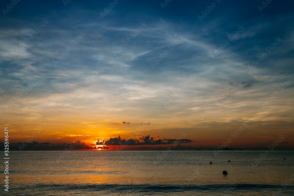 Sunrise, sunset of the sun through the clouds, tropical area near  sea.