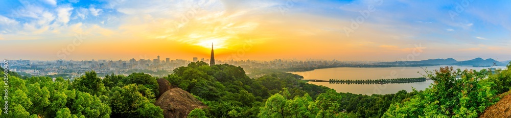 Panoramic city skyline and green mountains at sunrise in Hangzhou,China.