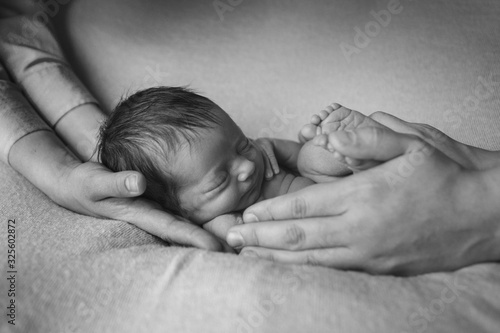Newborn baby lying on hands of parents. Imitation of baby in womb. beautiful little girl sleeping on her back. manifestation of love. Health care concept, parenthood, children's Day, medicine, IVF