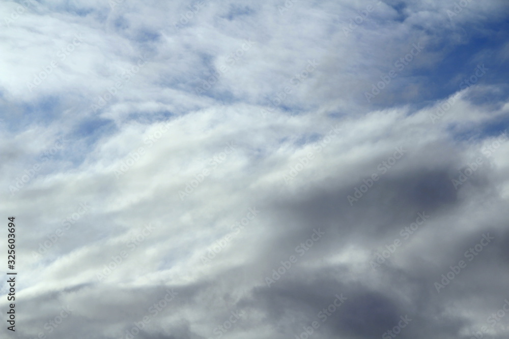 Fototapeta premium Cloudy blue sky with white and gray clouds. Background for text and design